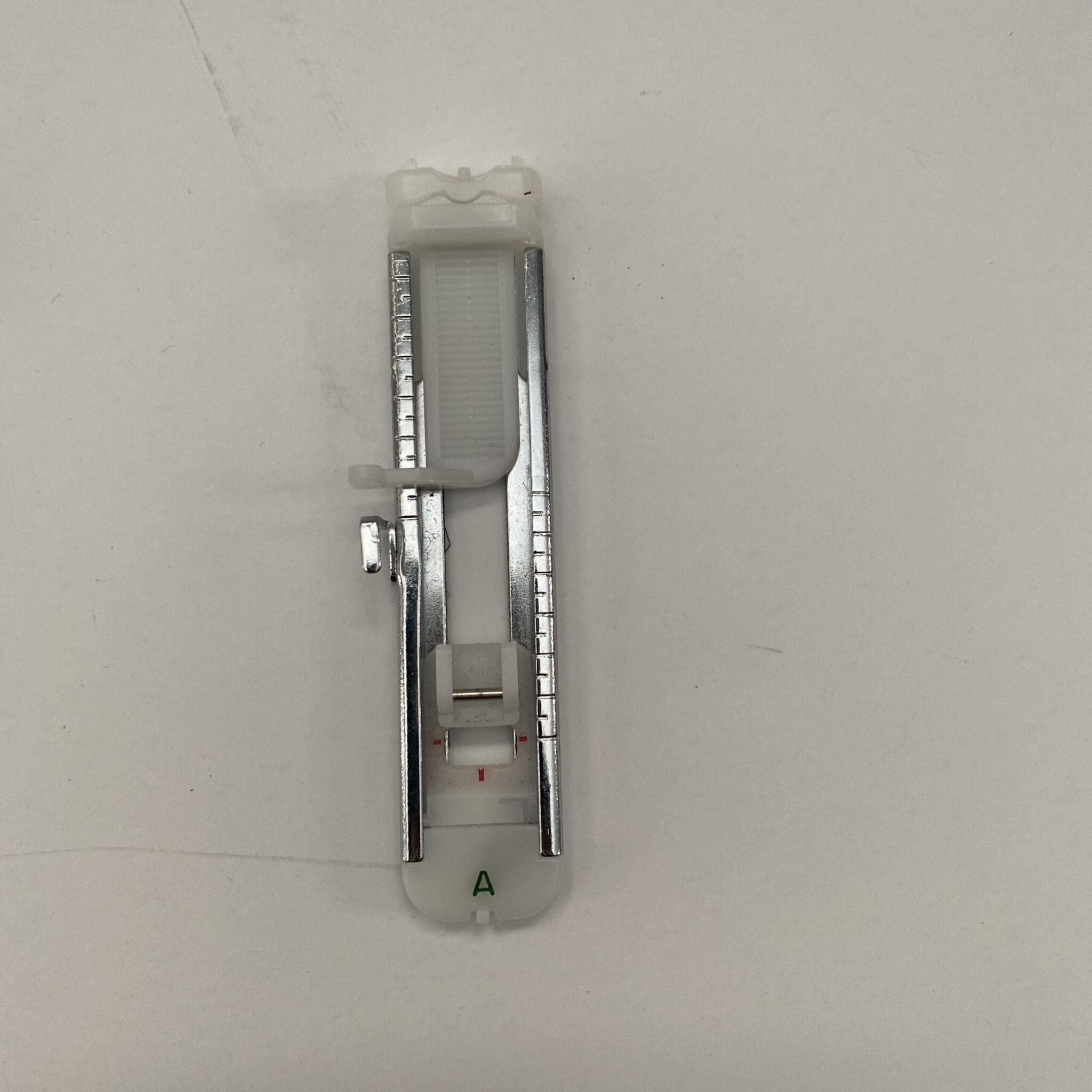 Button attachment presser foot holding a button on a sewing machine