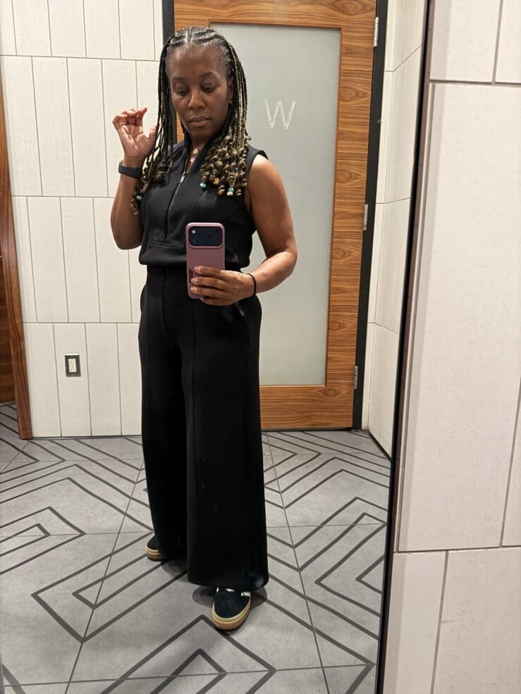 Restroom selfie showcasing the flattering fit of the Spanx AirEssentials Jumpsuit on a petite frame.