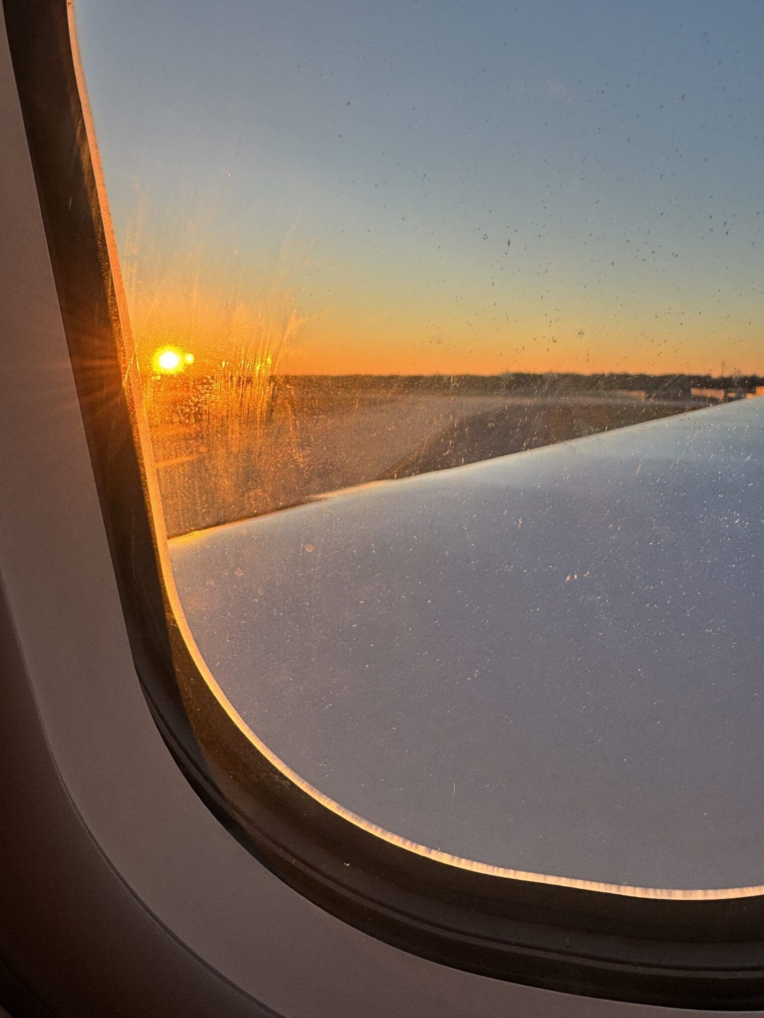 Warm amber sunrise LED mood lighting simulating dawn inside a wide-body airplane cabin.