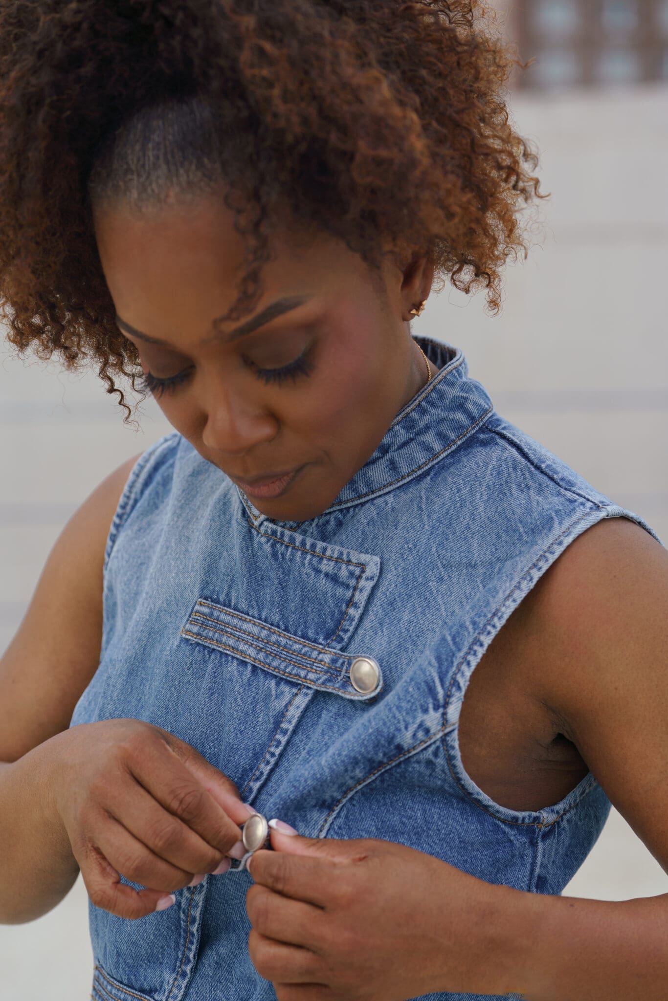 Petite style strategist walking with away carry-on luggage wearing double denim