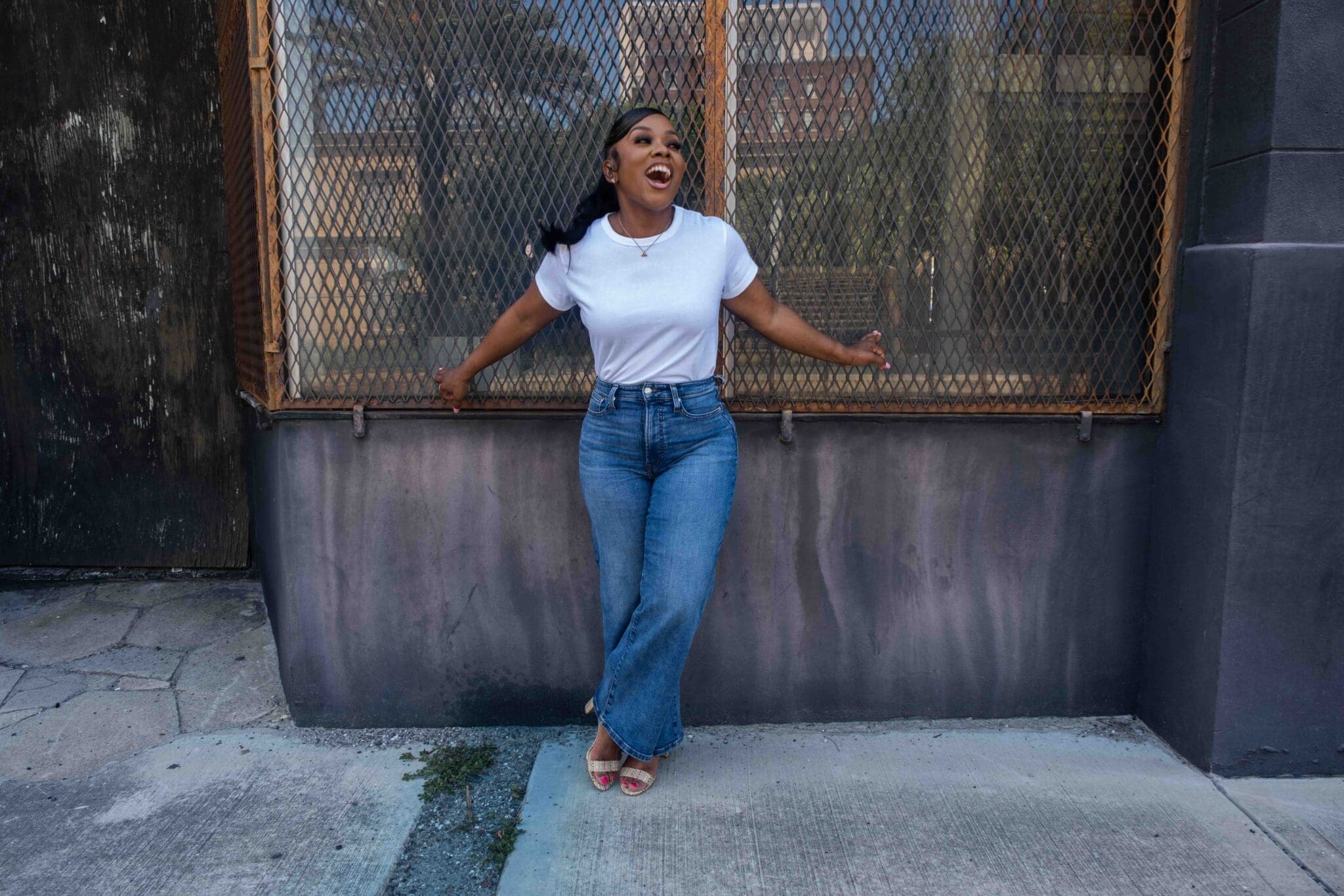 Dr. Shontae Buffington styling a crisp white tee and high-rise denim in an urban setting