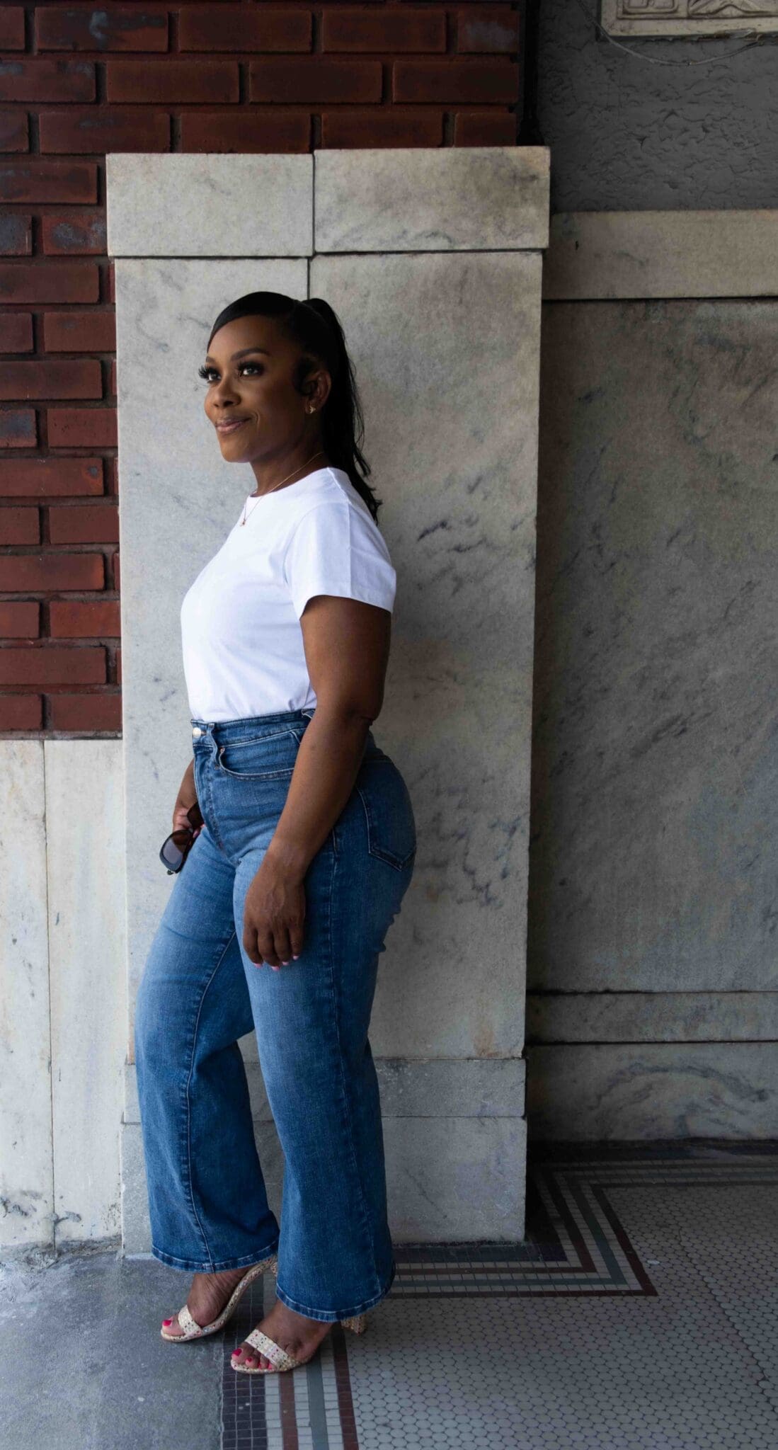 Profile view showing the rise, contour, and clean drape of wide-leg blue denim